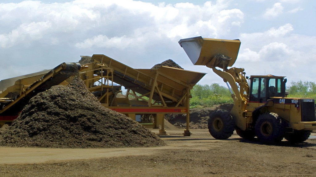 A wheel loader moves organic material inside a recycling yard