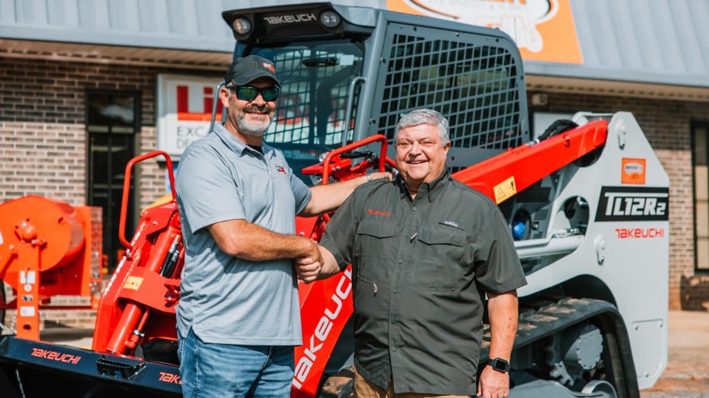 Eddie Bennett (right) shakes the hand of Scott Childress, the new owner of the 10,000th compact track loader produced at Takeuchi’s Moore, South Carolina, production facility.