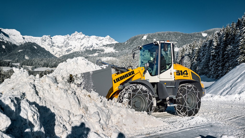 A Liebherr wheel loader moves a bucket of snow