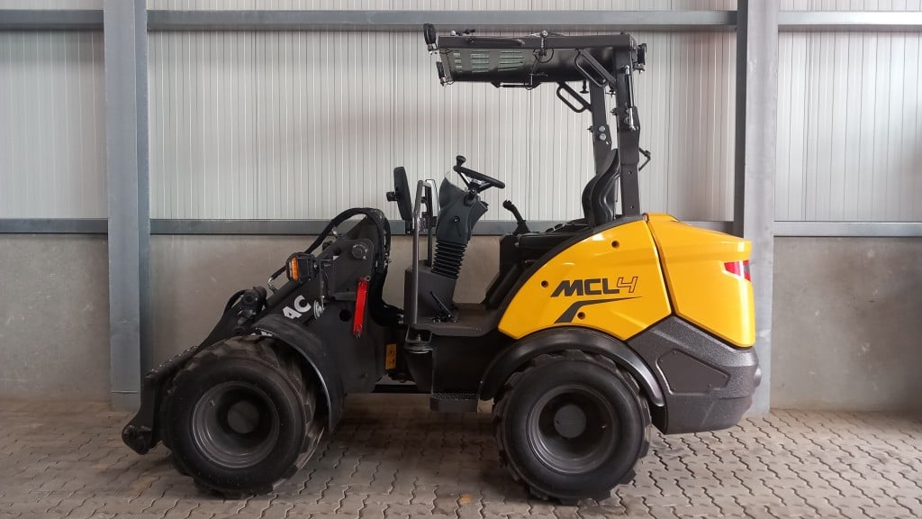 A Mecalac foldable-canopy compact wheel loader with the canopy extended in a warehouse