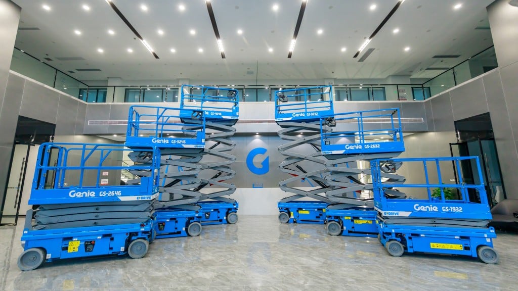 Six blue Genie scissor lifts in formation in a bright warehouse