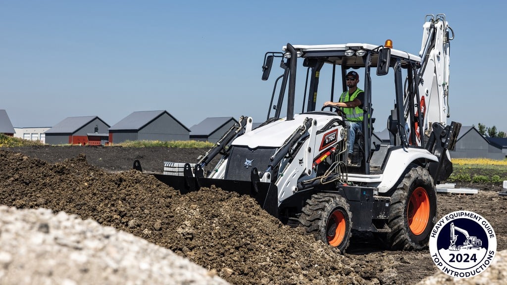 A Bobcat backhoe loader digs into a pile of dirt