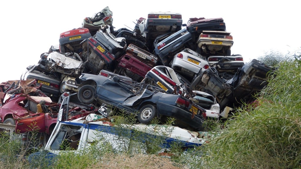 A pile of scrap cars in a field