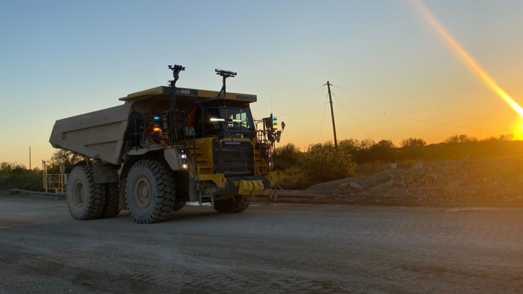 A large hauling vehicle driving up a gravel road