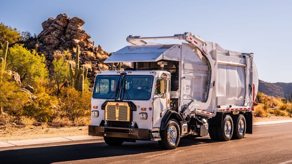 A large white truck driving down a road in the desert A large white truck driving down a road in the desert