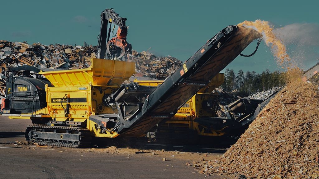 A large waste shredder in use at an outdoor yard A large waste shredder in use at an outdoor yard
