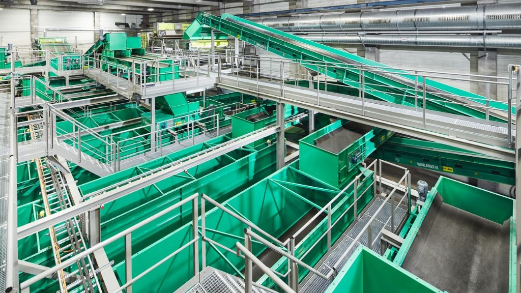 The interior of a large green and white plastics recycling line