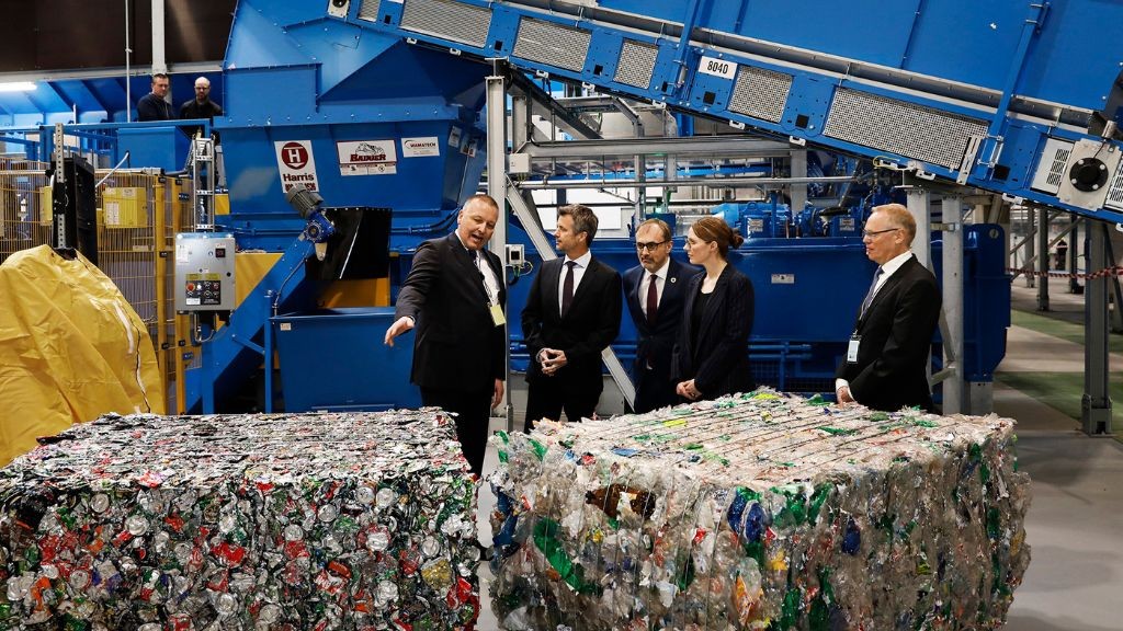 Several people wearing suits touring a plastics separation and compaction centre Several people wearing suits touring a plastics separation and compaction centre