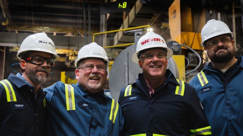 A group of four men wearing hard hats standing together for a photo A group of four men wearing hard hats standing together for a photo