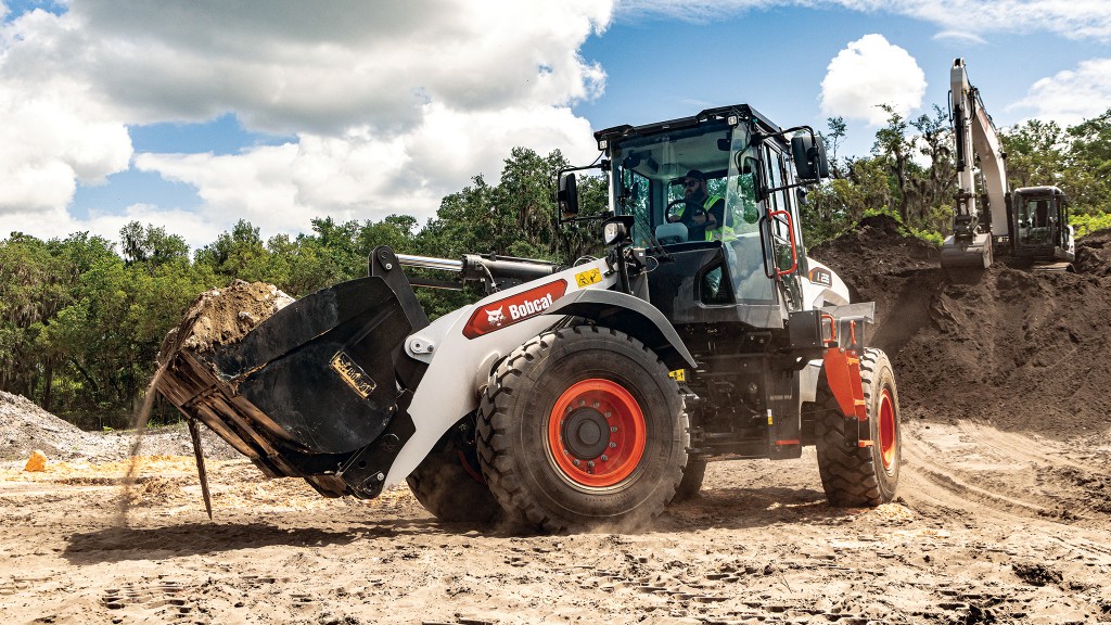 A large wheel loader next to a pile of large rocks and aggregates
