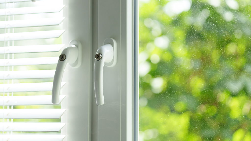 A close up photo of a vinyl white window with trees in the background A close up photo of a vinyl white window with trees in the background