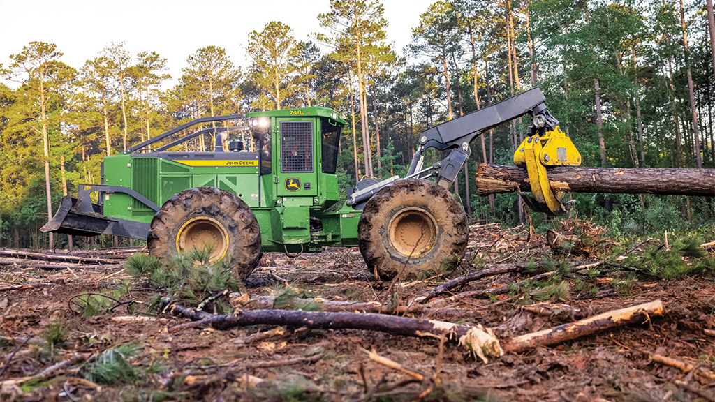 A green skidder holding a log