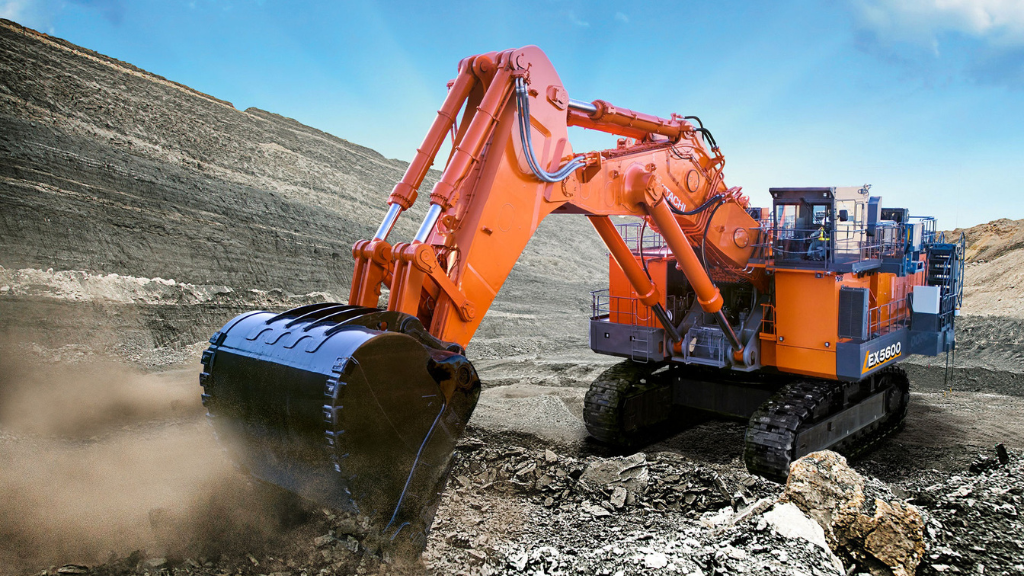 A large red hydraulic excavator digging with a bucket at an outdoor site