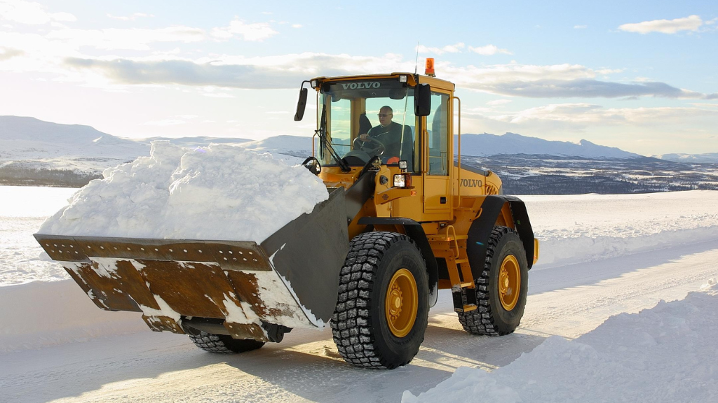 A wheel loader moving a bucket full of snow