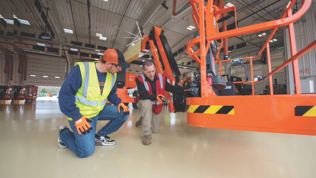 Two men looking at the basket of a telehandler