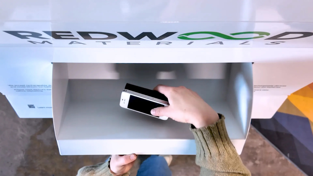 A person places a smartphone into a collection bin
