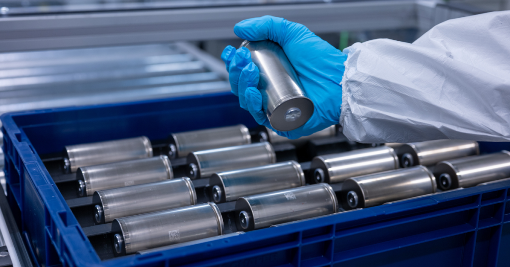 A person wearing blue gloves holds a battery fuel cell