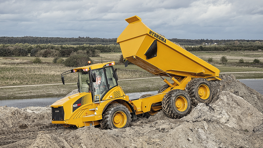 An articulated dump truck unloads its bed of aggregates