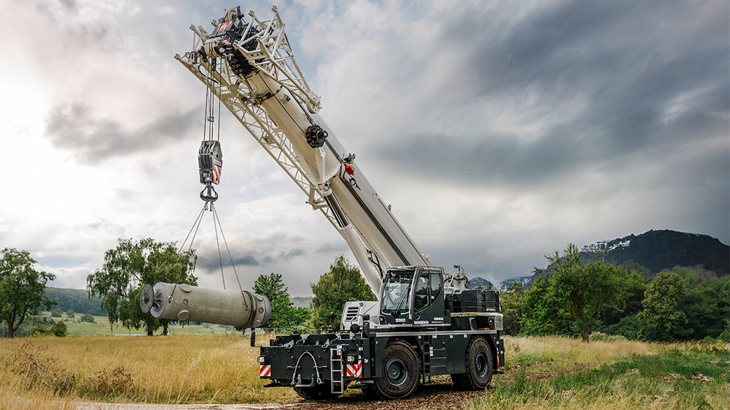A rough terrain crane sits in a field
