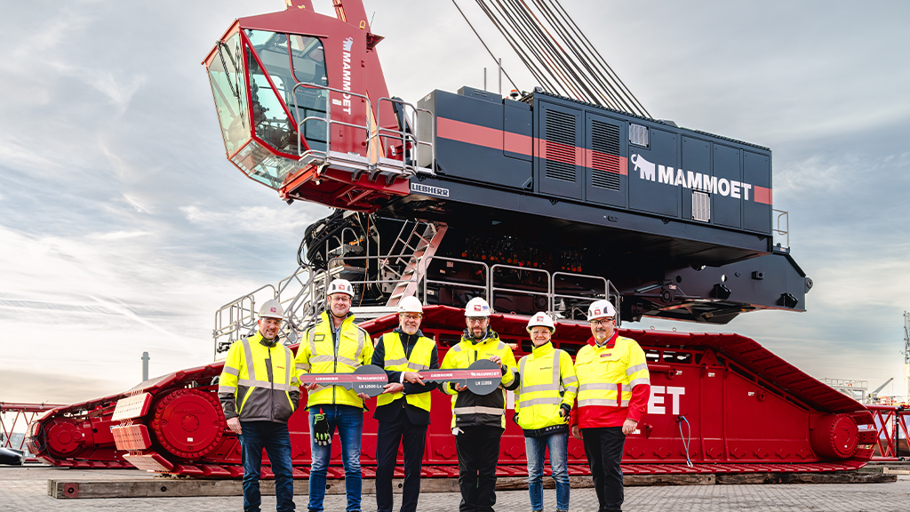 Several men stand in front of a large crane with a large key