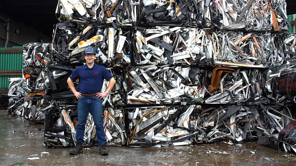 Dan Lundquist poses in front of a wall of baled metal scrap.