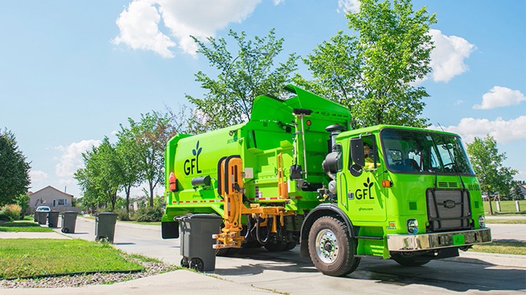 A green collection trucks picks up a household bin A green collection trucks picks up a household bin