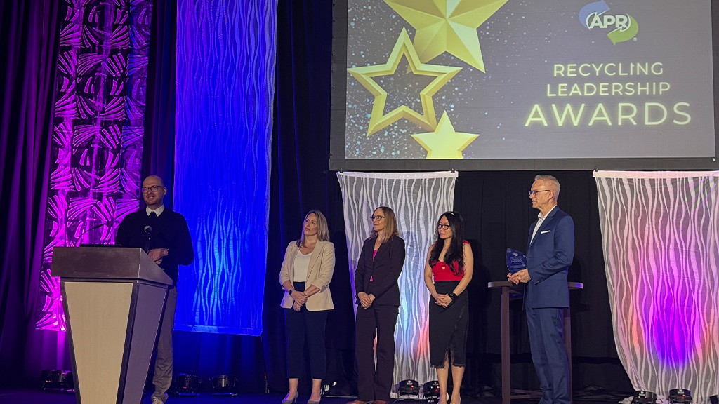 A group of people on stage next to a man standing at a podium