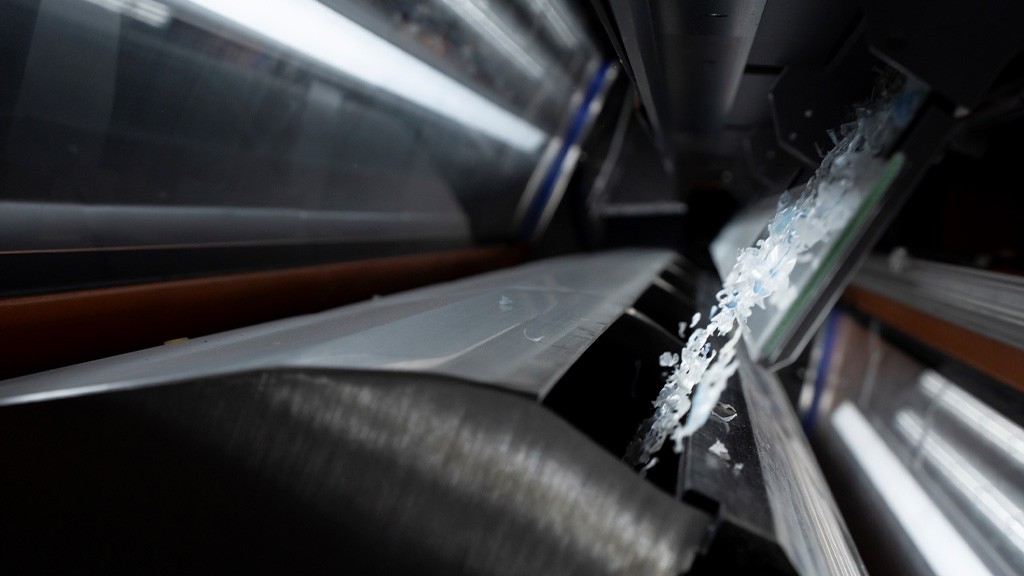 Small plastic flakes moving through an industrial recycling machine