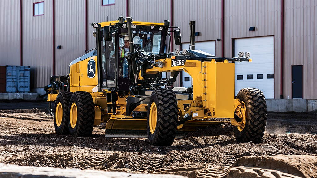 A man drives a motor grader on soft soil A man drives a motor grader on soft soil