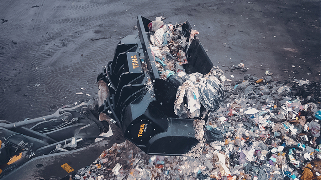 An aerial view of a multi waste bucket moving recyclable waste material An aerial view of a multi waste bucket moving recyclable waste material
