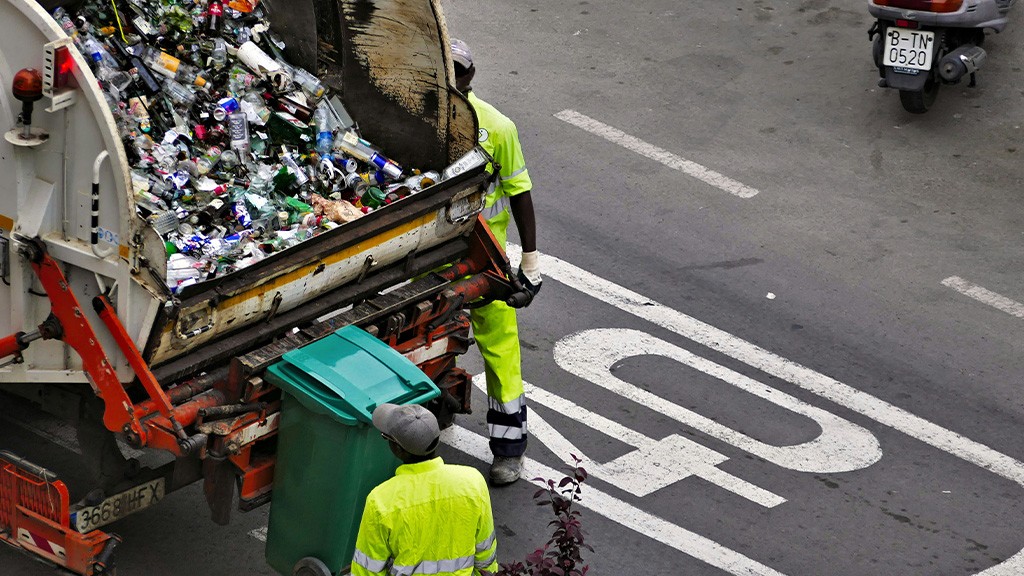 Two workers stand behind a refuse collection vehicle Two workers stand behind a refuse collection vehicle