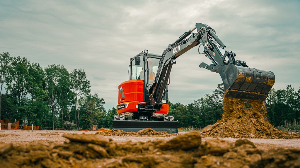 A mini excavator lifts a bucket of soil A mini excavator lifts a bucket of soil