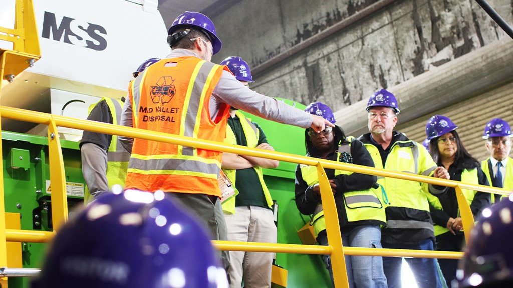 Several people wearing full PPE inside of an MRF