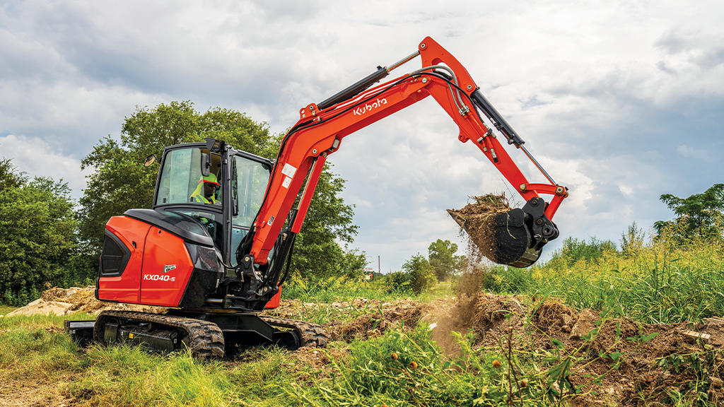 An excavator picks up a bucket filled with dirt