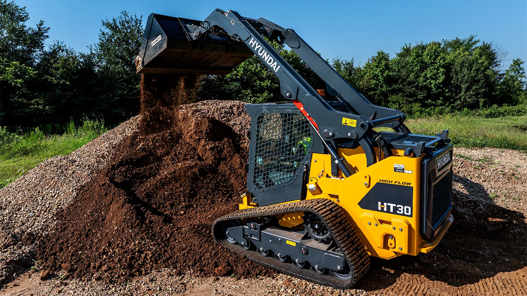 A compact track loader lifting a bucket filled with soil A compact track loader lifting a bucket filled with soil