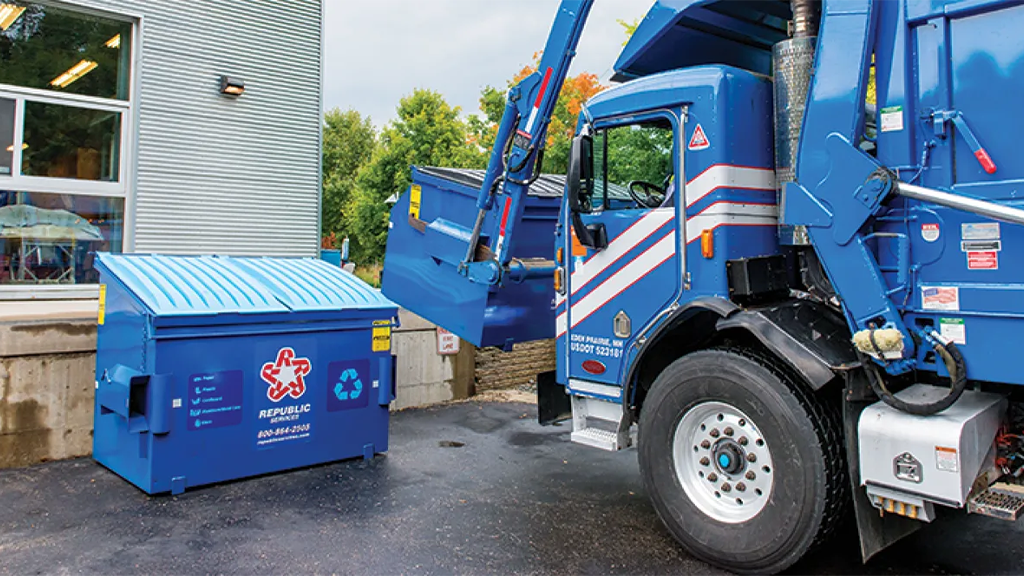 A collection vehicle picks up a dumpster A collection vehicle picks up a dumpster