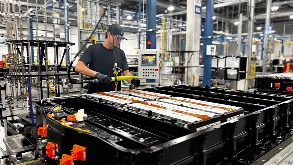 A man working next to a large EV battery pack