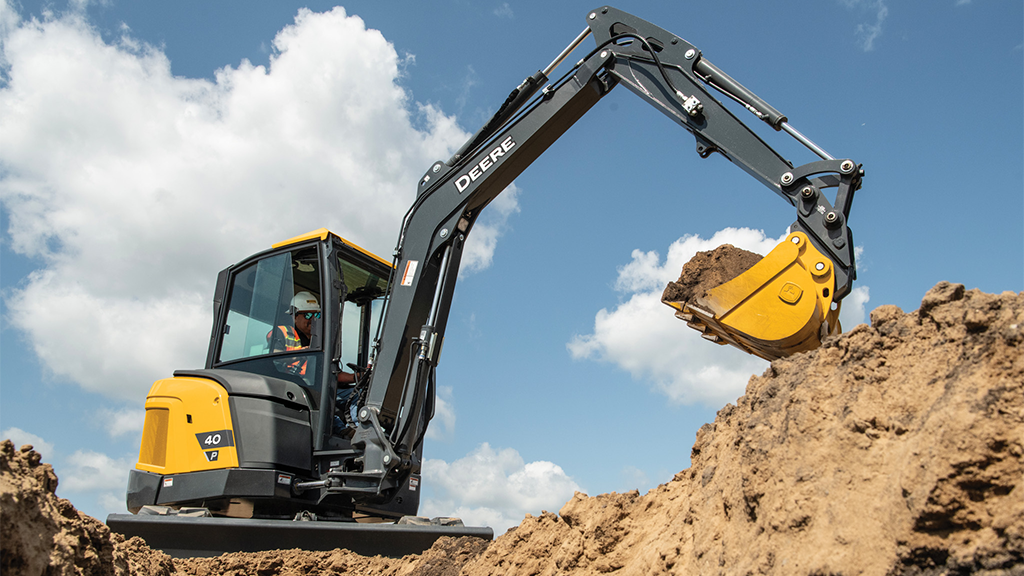 A compact excavator lifts a bucket of soil