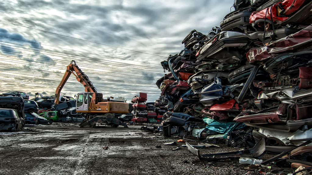 A material handler works in an automobile scrap yard A material handler works in an automobile scrap yard